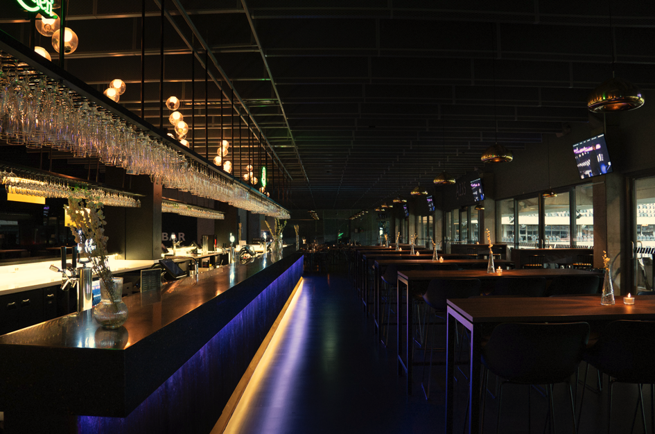 Bar – lång bardisk med blå belysning och hängande glas på 3Arena, Globen