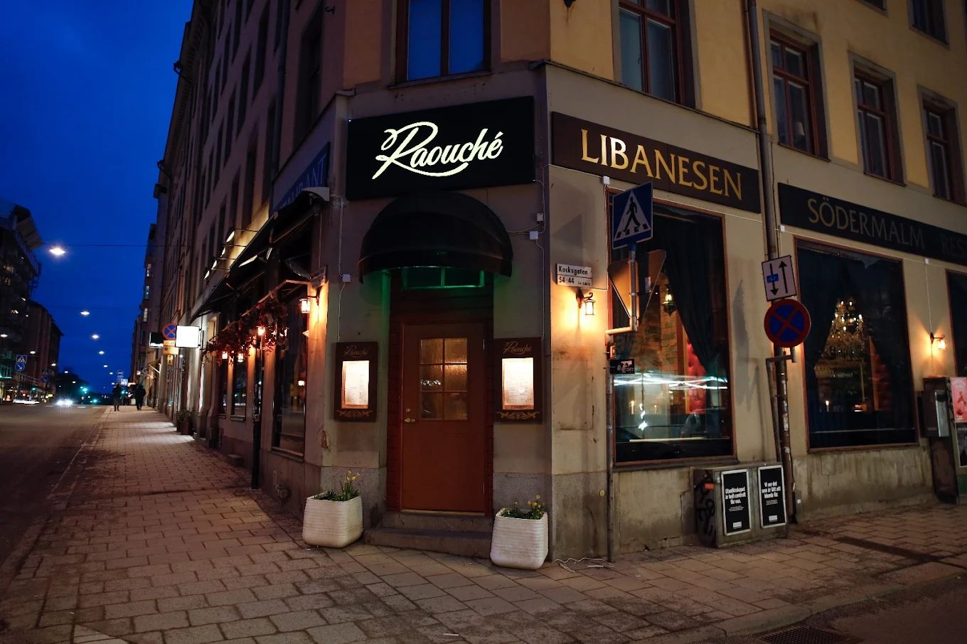 Exteriör – Raouche Libanesiskas hörnentré med skyltar i kvällsljus på Södermalm i Stockholm