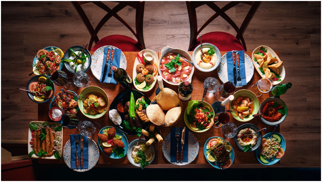 Maträtt – libanesiskt mezebord ovanifrån med falafel, hummus och nybakat bröd på Raouche Libanesiska