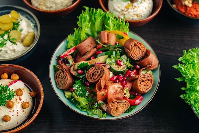 Maträtt – salladsskål med granatäpple omgiven av meze på Beirut Foodbynatt i Hammarby Sjöstad